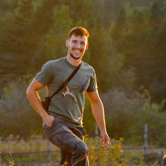 Man standing in a field with trees in the background