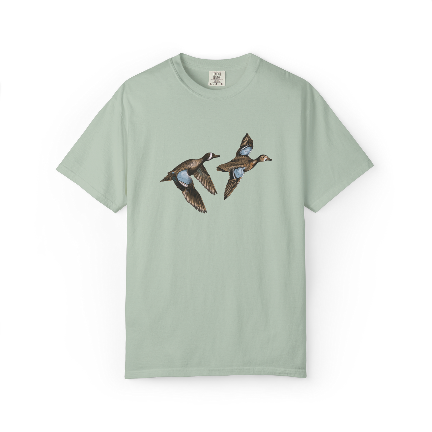 A light green t-shirt featuring an illustration of two blue-winged teal birds in flight.